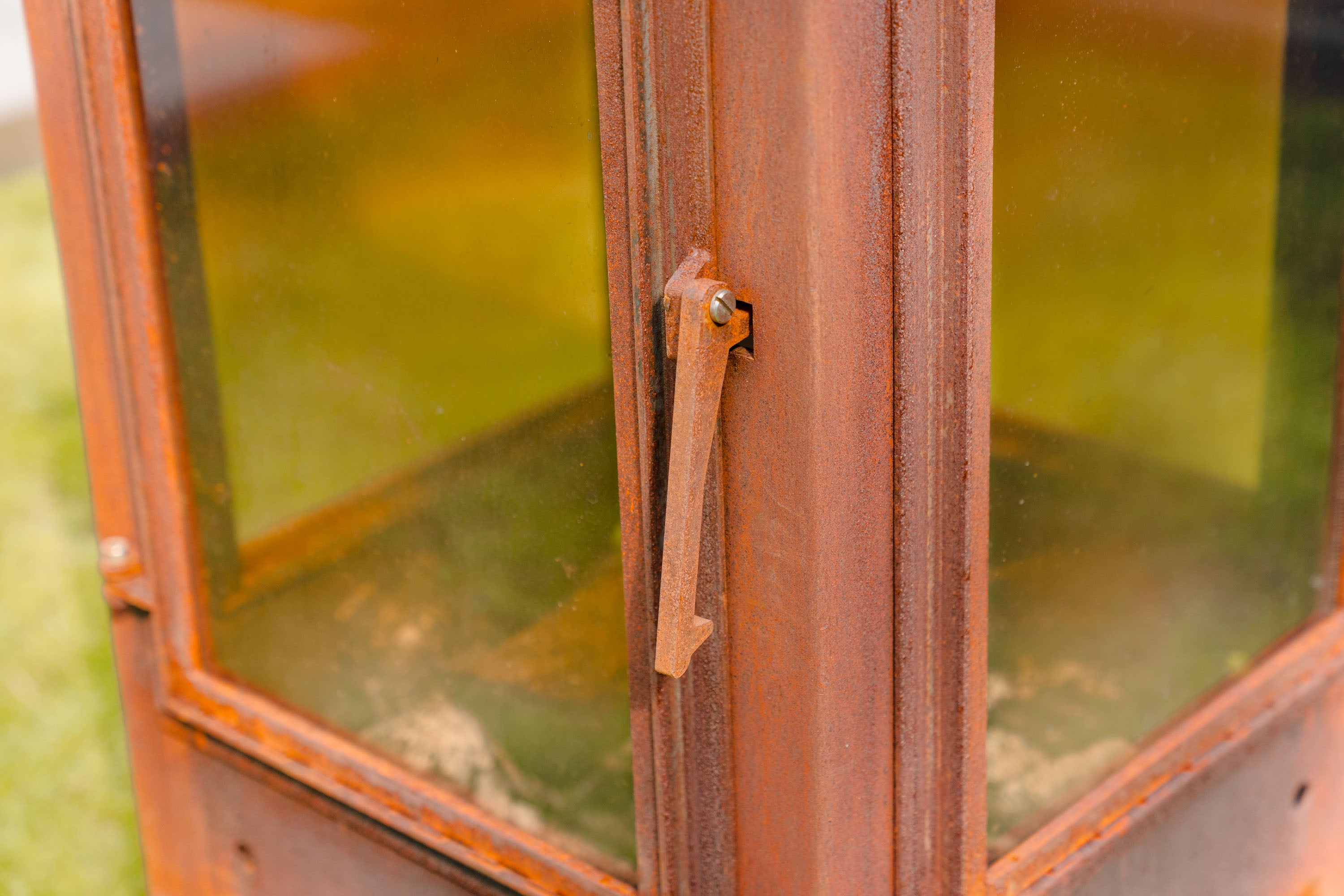 Close-up of a brown leather suitcase with a green background