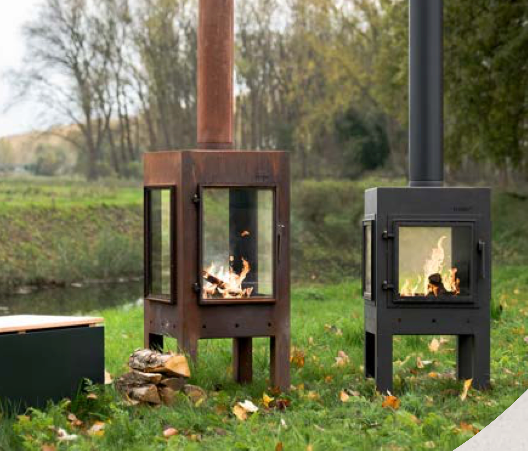 corten and black outdoor fireplaces with glass panels. burning wood . set on grass
