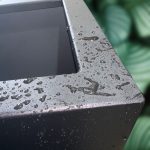 Coated steel planter with a textured surface on a blurred natural background