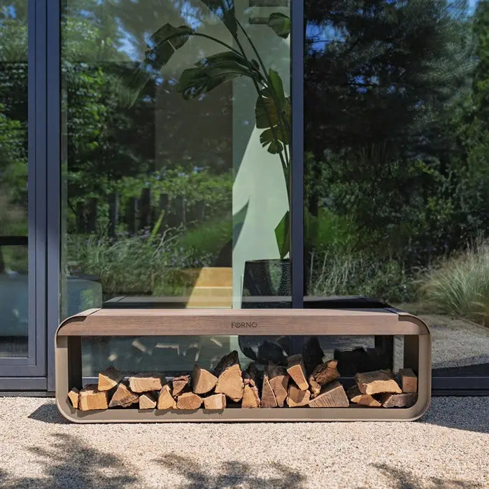 Outdoor fire pit with kindling in front of a glass door