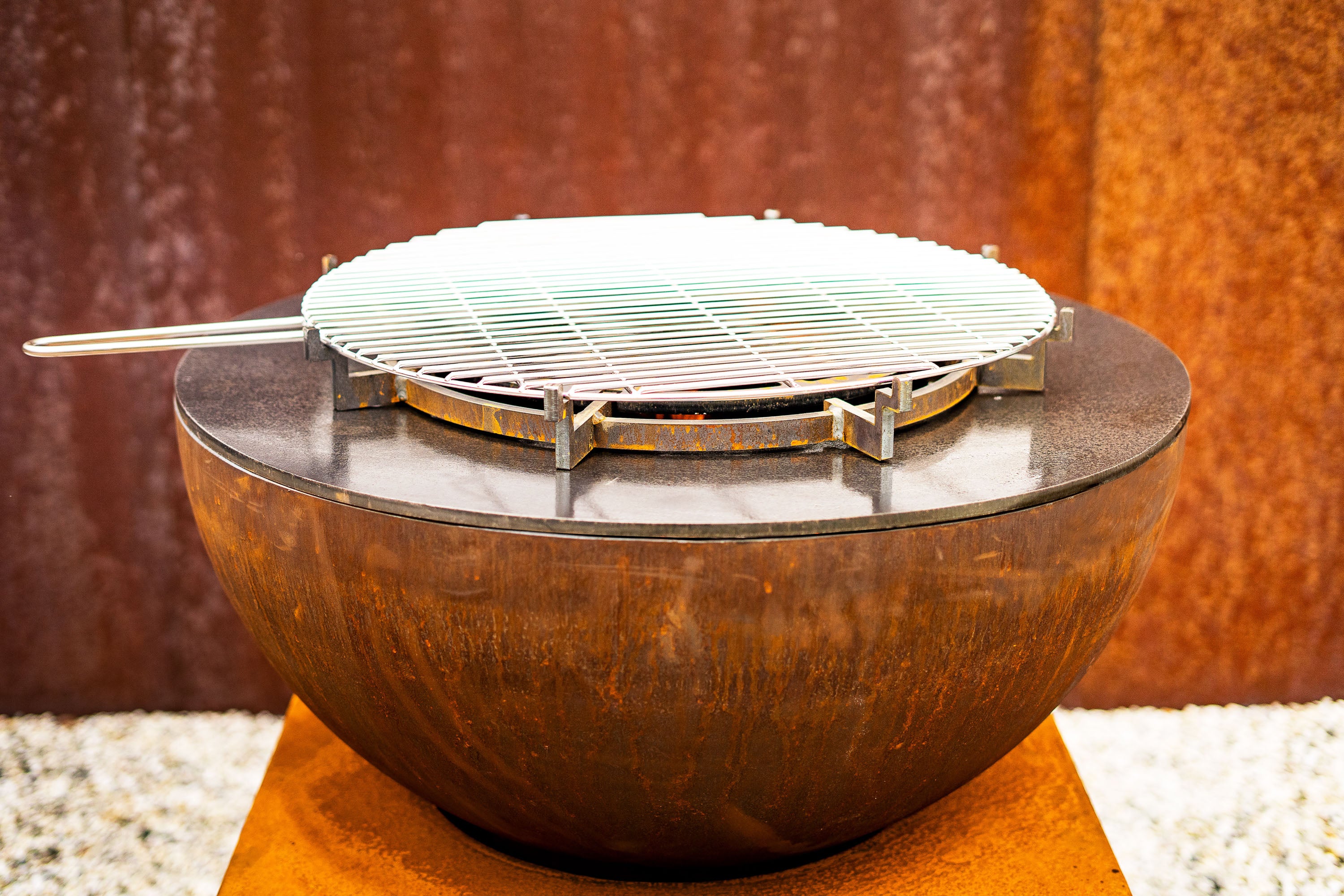 grill resting on top of round corten bbq