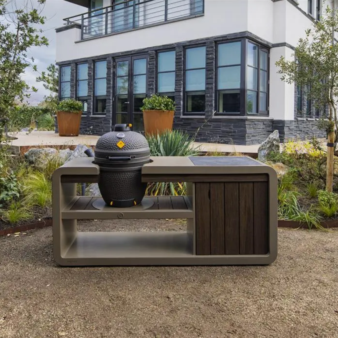 egg bbq with surrounding work station in front of a house