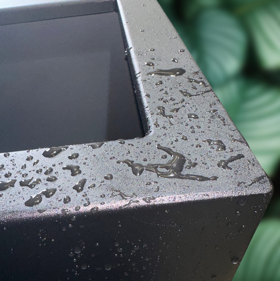 Close-up of a textured black surface with water droplets, possibly outdoor setting.