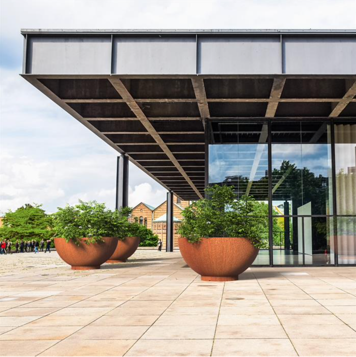 three large bowl corten planters. Planted up with shrubs