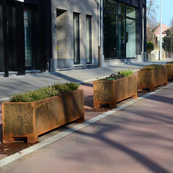 row of corten steel trough planters on a pavement