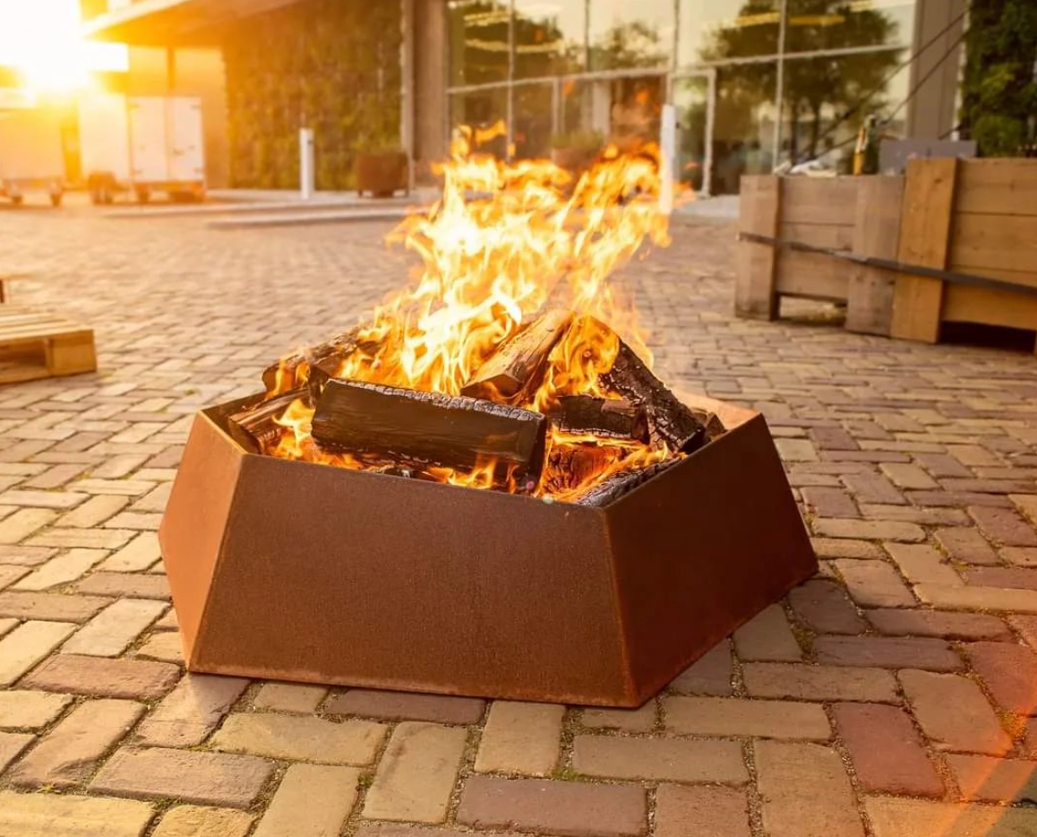 corten steel fire bowl with angular edges, lit
