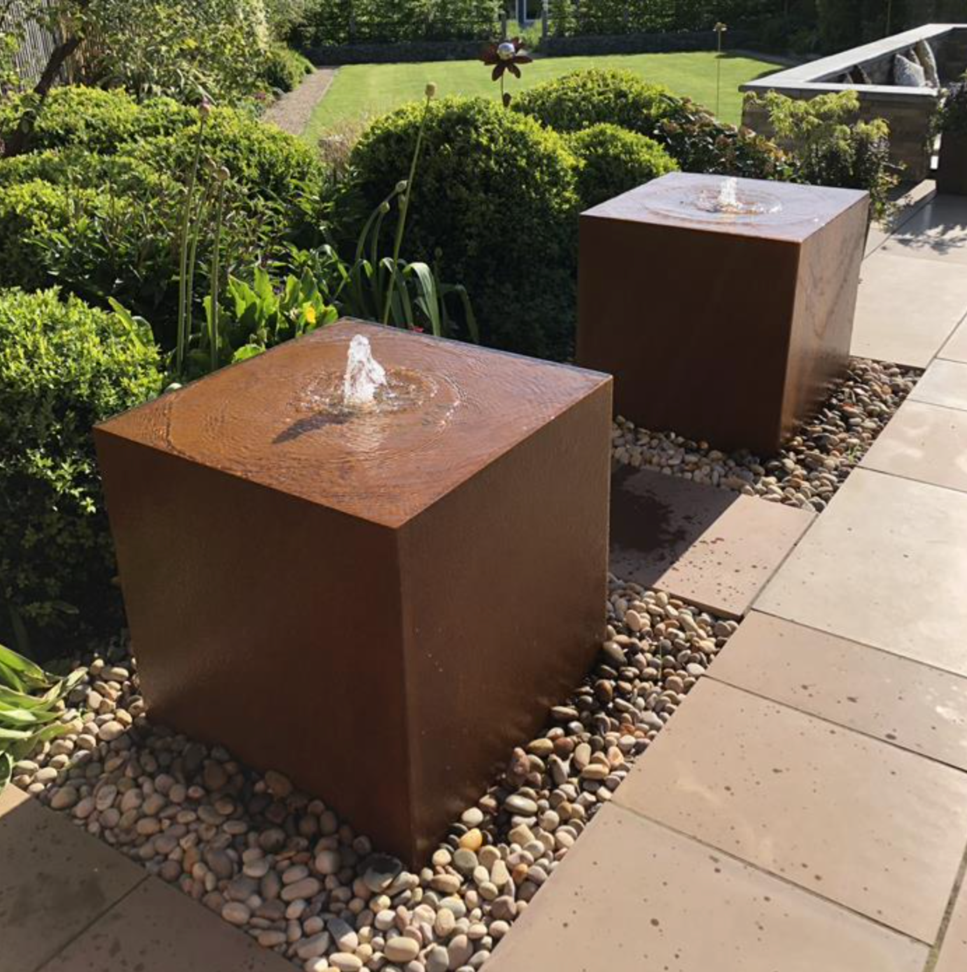 two corten steel water blocks filled with water