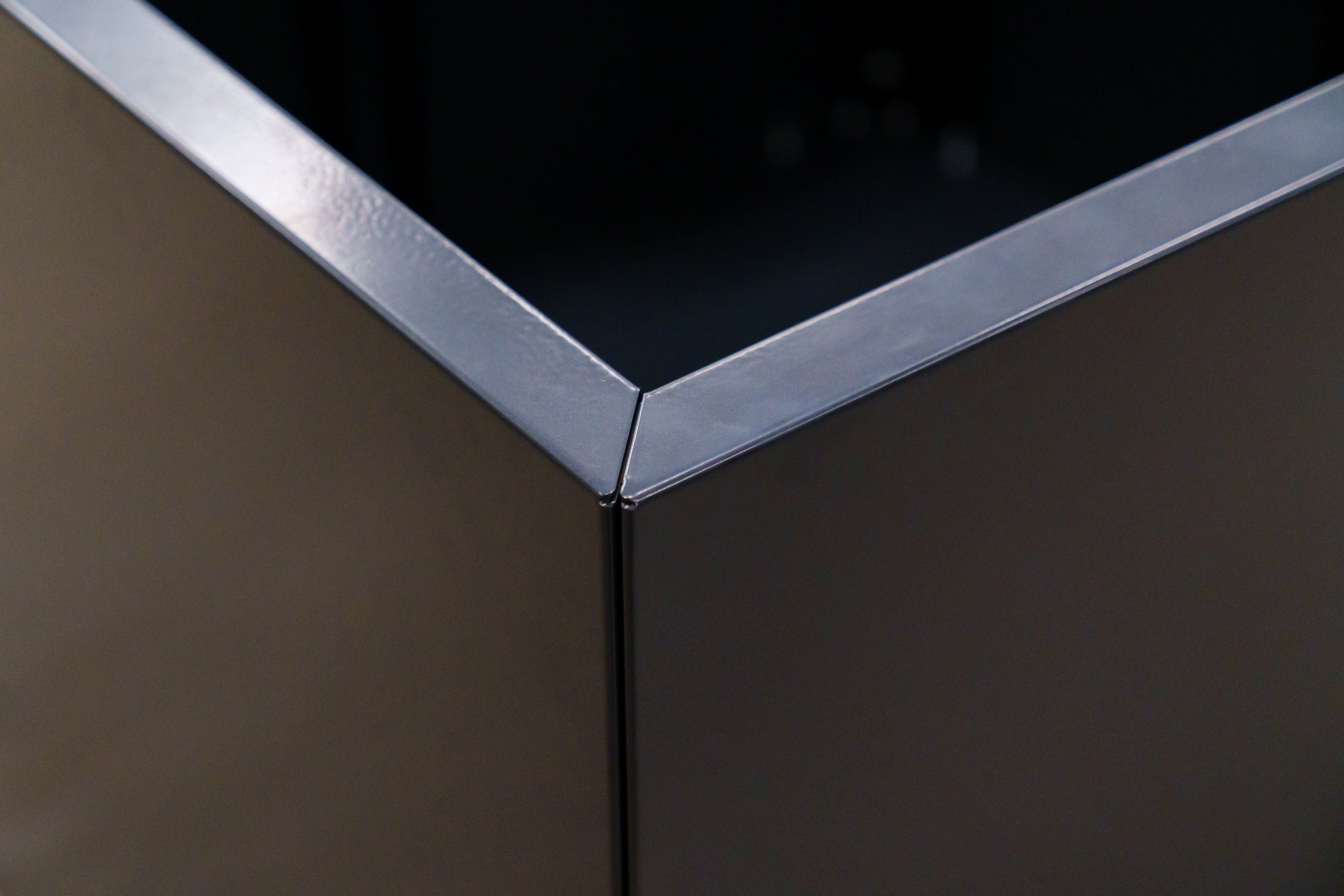 Close-up of a corner with metallic trim on a dark surface