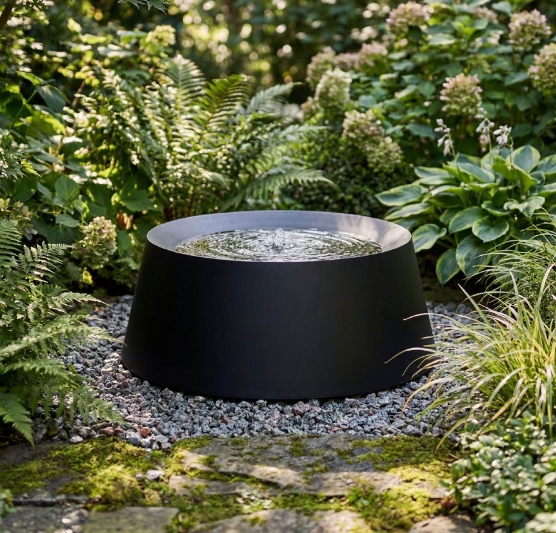 Black garden water feature surrounded by greenery