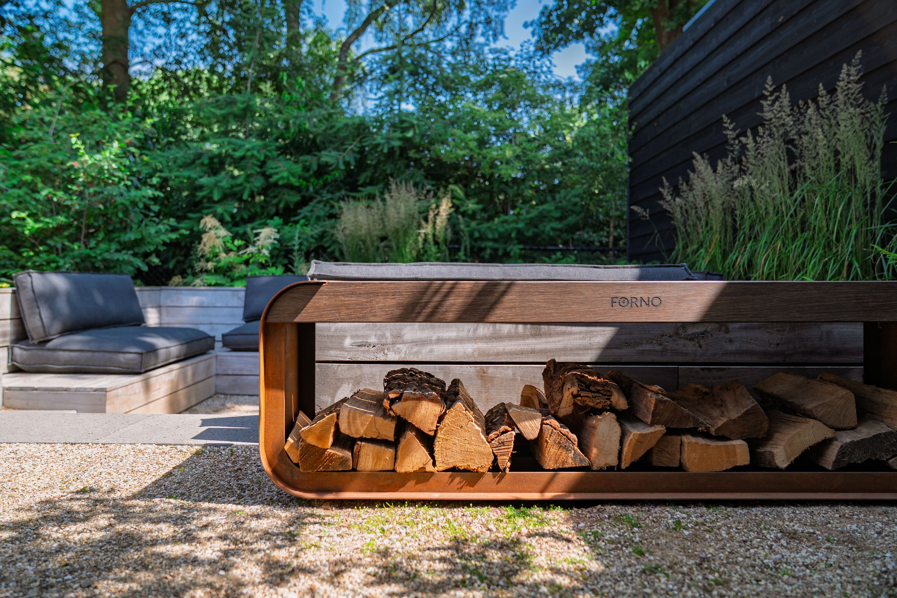 Wooden firewood holder with stacked firewood in an outdoor setting with greenery.