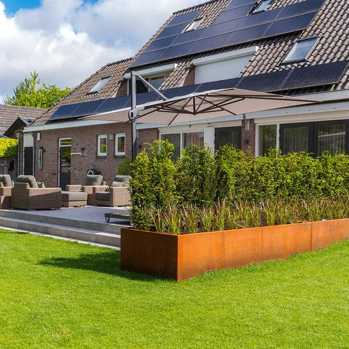 corten steel l shape garden planter on lawn beside a patio
