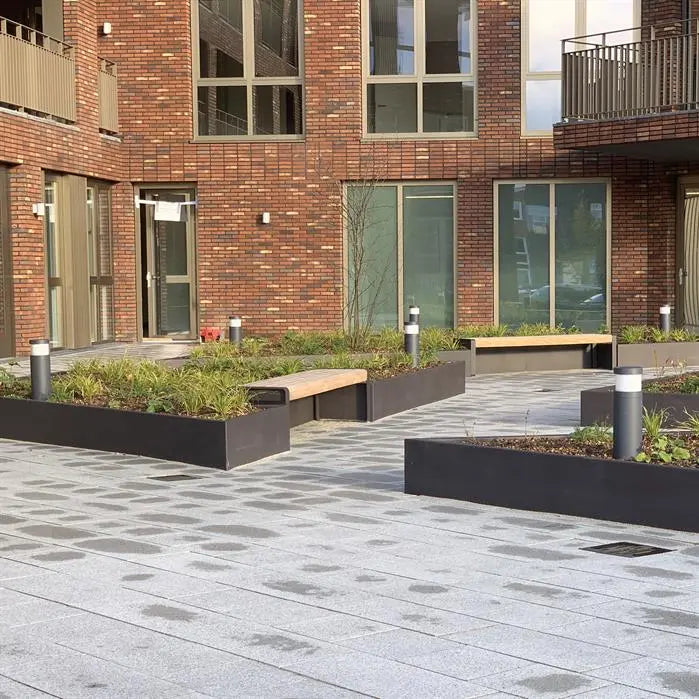 black retaining walls around flower bed in public area