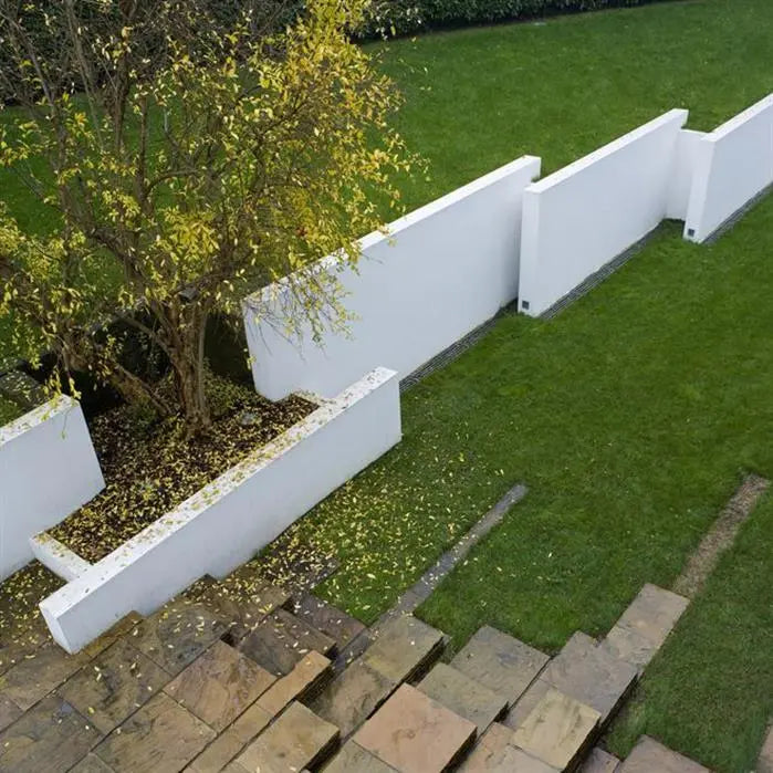 Garden with white walls, green grass, and a tree