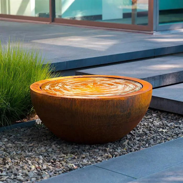 round corten pond filled with water set on gravel