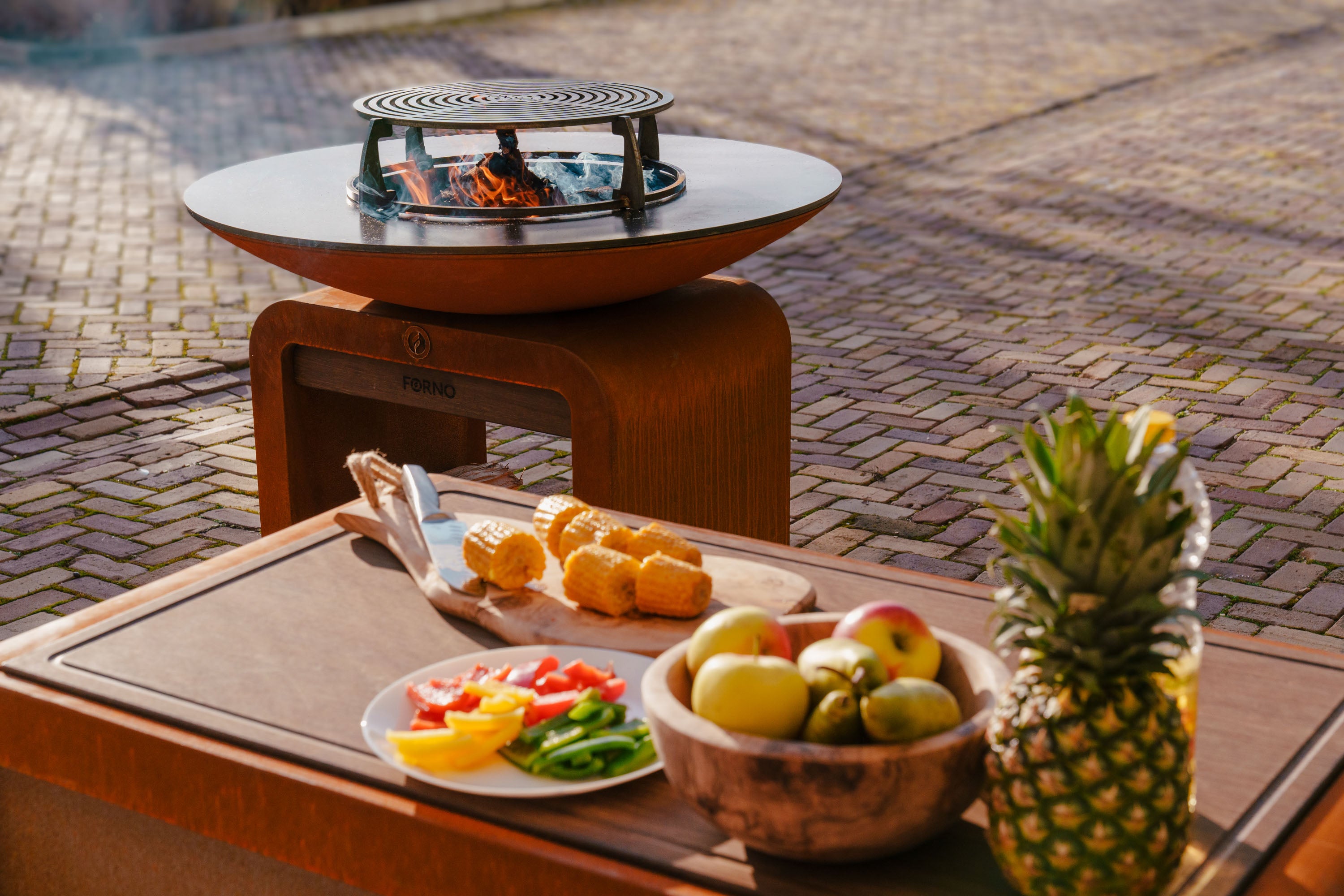 Fire pit table with food and fruits on a patio