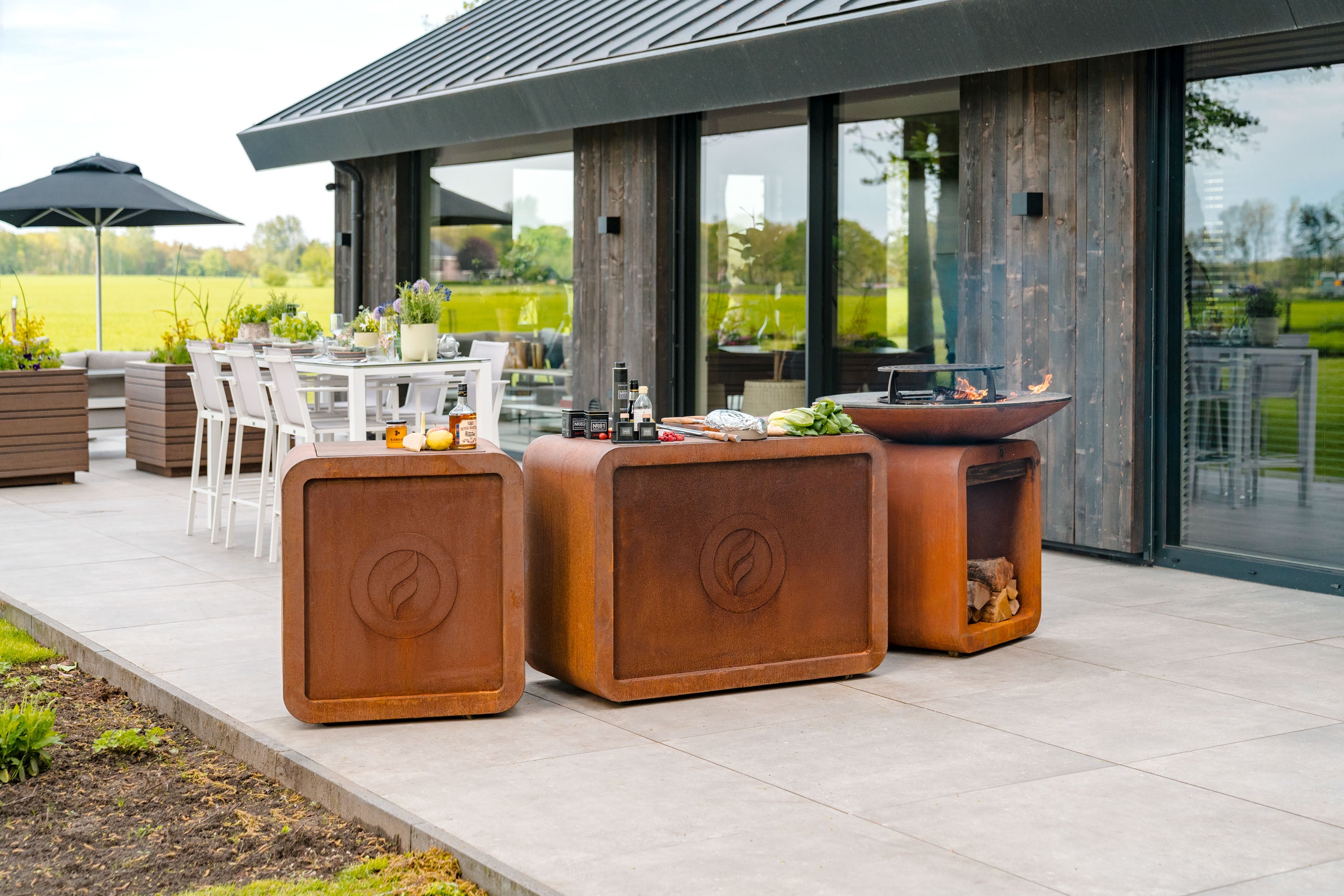 Outdoor patio setting with brown outdoor furniture and a view of a house.