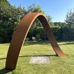 corten steel curved arch on grass