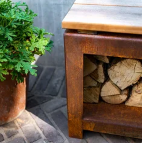 Wooden bench with firewood storage and a potted plant on a stone patio