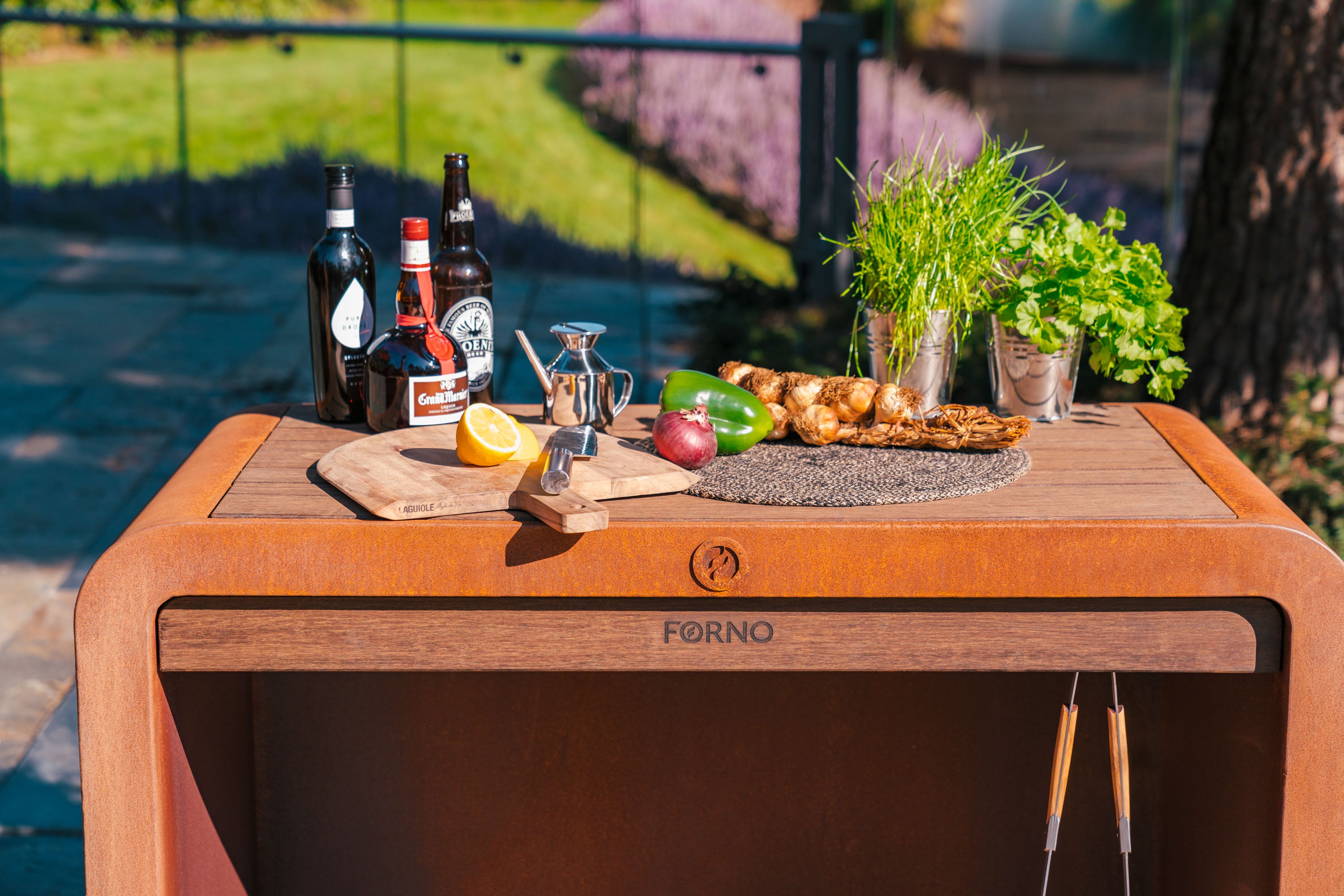 Outdoor setting with a wooden table displaying food and drinks, branded 'Forno'.