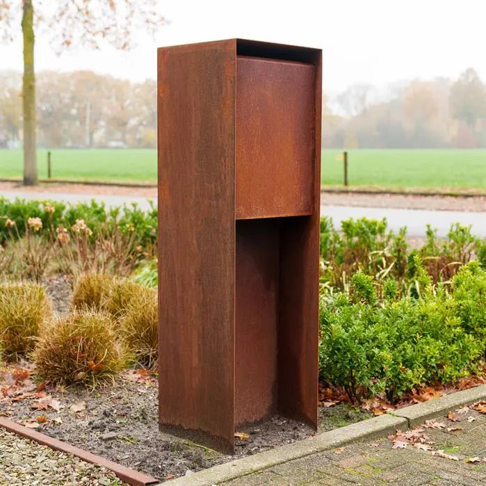 plain corten letterbox on flower bed next to pavement