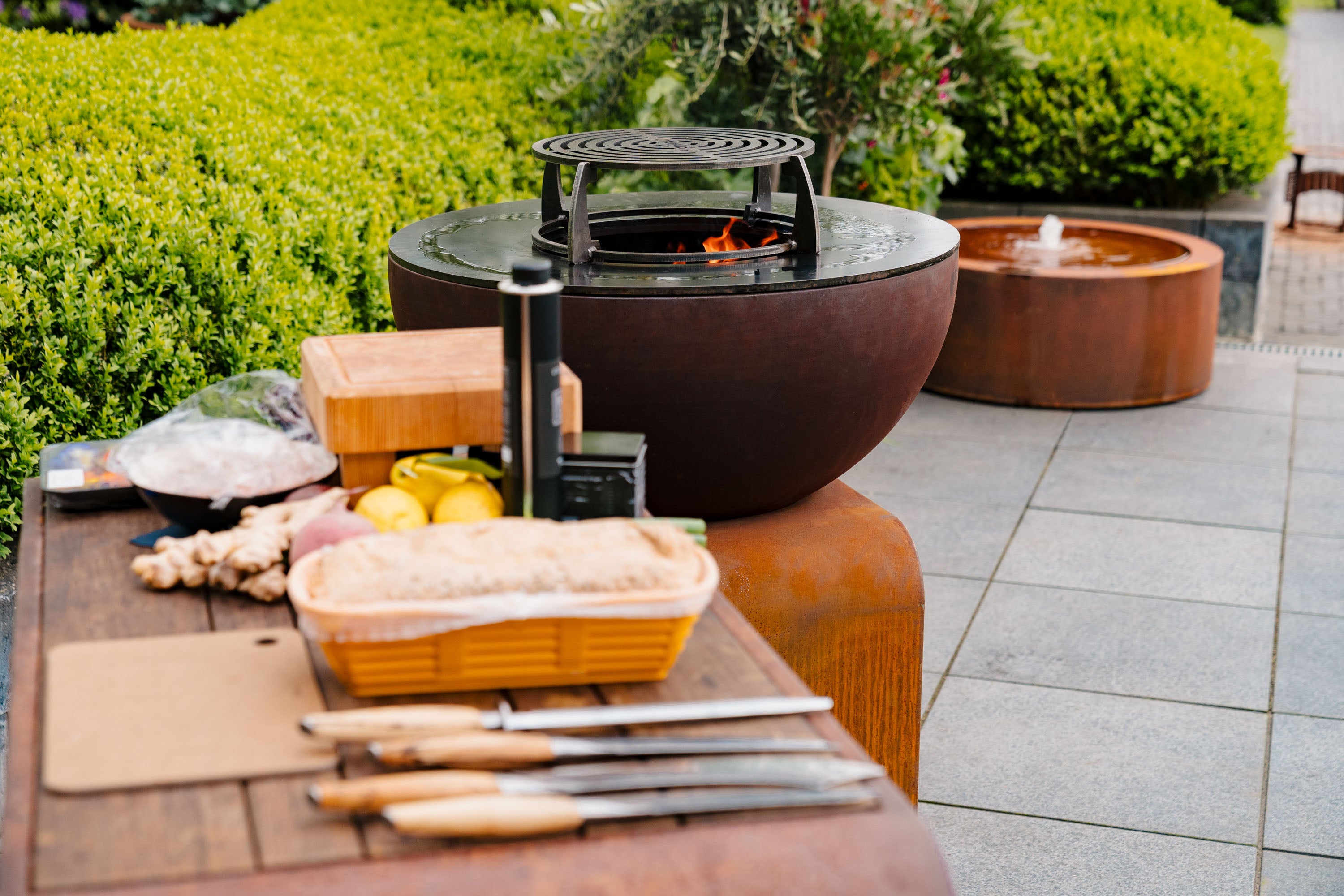 corten grill alight next to bench with food preperation
