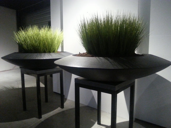 two striking black fiberglass disc shaped garden planters 
