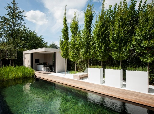 three white trough planters in a row next to a natural pool