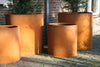 different sized large round corten steel outdoor planters
