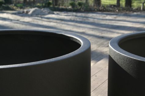 detail of a pair of round black fibreglass garden planters 