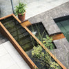 rectangular corten steel pond filled with water and plants